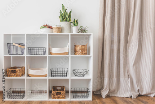 White stylish shelf in scandi style. Storage baskets. Japanese method organizer boxes set. Closet organizing concept.