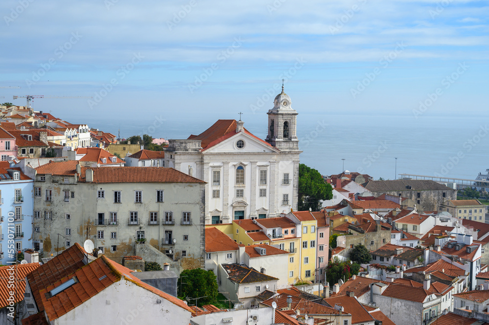 Lisbon, Portugal, November 6, 2022. View from viewpoint terrace on old part of Lisbon in Alfama, white houses with tiled roofs, river Tejo, port