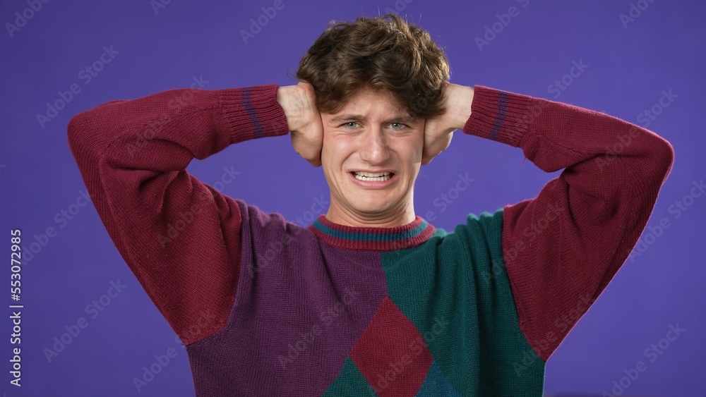Young man covers close ears do not want to listen screaming loud noise ...