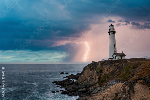 Pigeon Point Lighthouse and house on Pacific coastal by beautiful seascape with cloudy sky and thunderstorm in the background at sunset