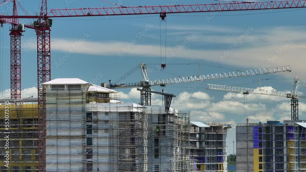 Aerial view of tower cranes and frame structure of high residential apartment buildings at construction site. Real estate development Aerial view of tower cranes and frame structure of high residential apartment buildings at construction site. Real estate development