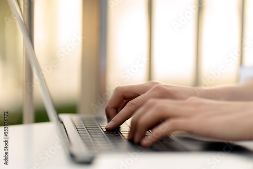Close up of copywriter hand typing on keyboard, working online, selective focus. Business woman using laptop computer shopping online 