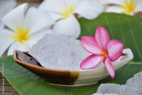 Alum cubes on ceramic pot and plumeria flowers background  concept for herb  bodycare  skincare  waterclear  spa  treatment  disease protection and protect armpit smell. 