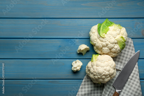 Fresh cauliflowers on light blue wooden table, top view. Space for text