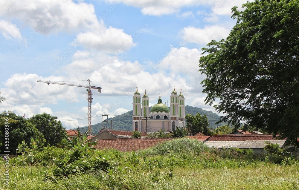 Obraz premium Serang, Banten, Indonesia - November 2022. Musholla Nurul Iman (Kp. Larangan, Harjatani - Kramatwatu) from a distance, with Gunung Pinang as the background.
