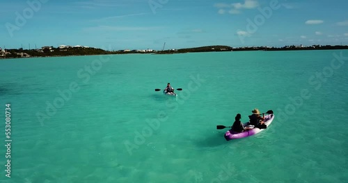 Tourists riding a boat in the open, clear, and shallow water of Turks And Caicos, Atlantic, North America 4K UHD. photo