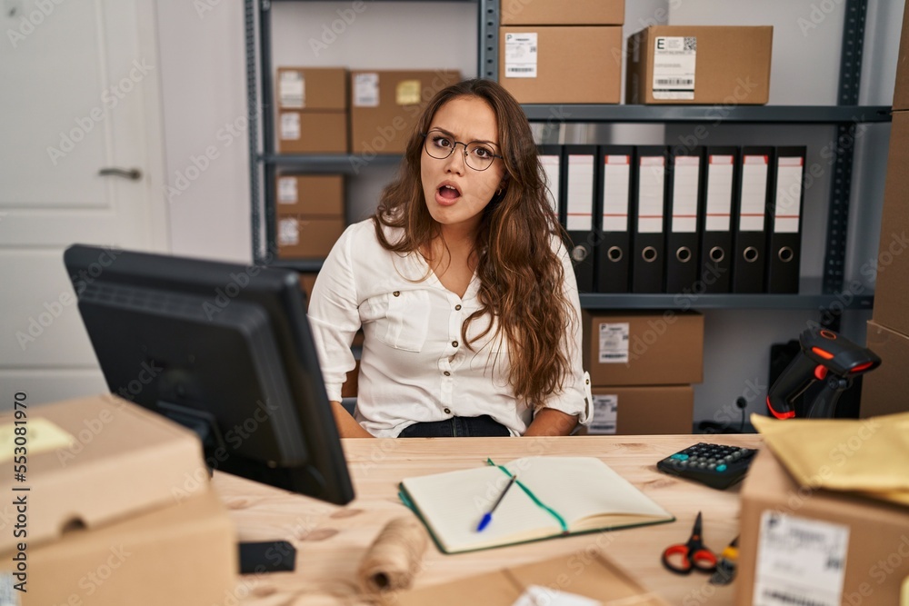 Young hispanic woman working at small business ecommerce in shock face, looking skeptical and sarcastic, surprised with open mouth Young hispanic woman working at small business ecommerce in shock face, looking skeptical and sarcastic, surprised with open mouth