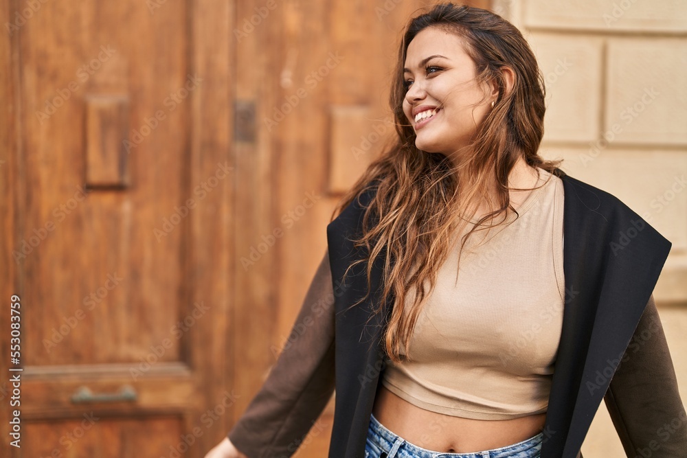 Fototapeta premium Young beautiful hispanic woman smiling confident looking to the side at street