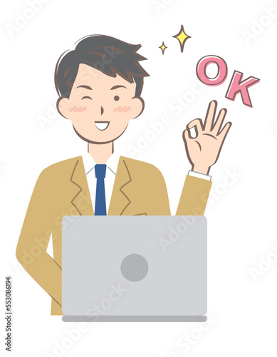 パソコン操作でOKサインを出すスーツ姿の若い男性