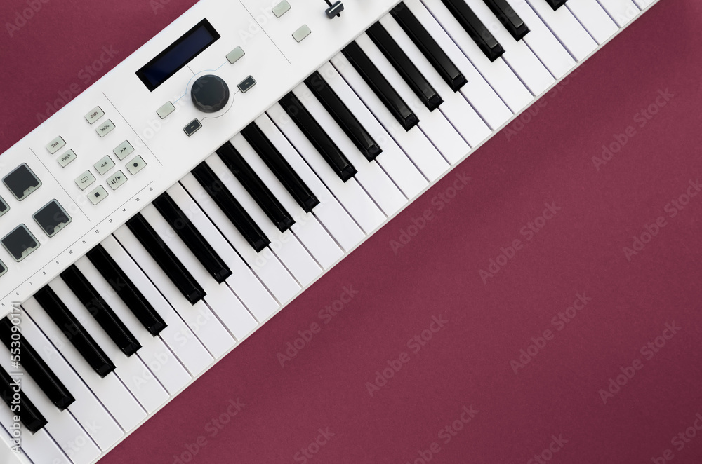 Fototapeta premium Midi keyboard on magenta background, flat lay, musical creativity concept, copy space.