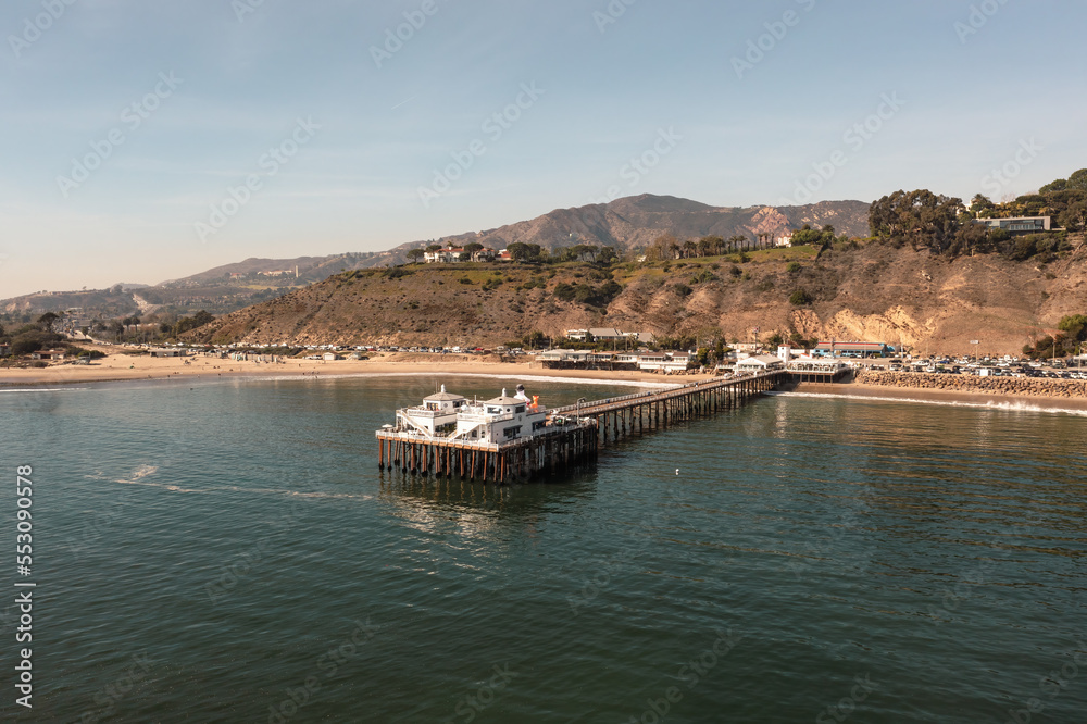 Aerial of historic Malibu Pier, Pacific Coast Highway and the Santa Monica Mountains 