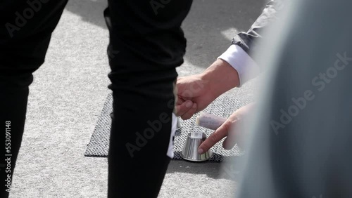 Closeup of street gambling on follow the ball trick at Westminster bridge. Fraudster exhibits great manual dexterity. Money on hand. Viewers and accomplice around him to cover and defraud gamblers.