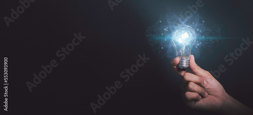 Artificial intelligence of futuristic Innovative technology concept. Businessman hand holding light bulbs or lamp thinking ideas with AI brain genius analysis business in black background.