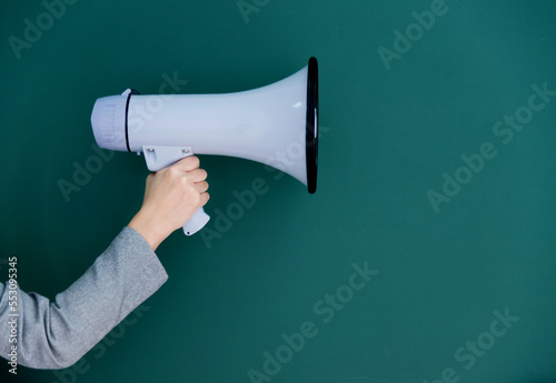 Woman holding megaphone on chalkboard