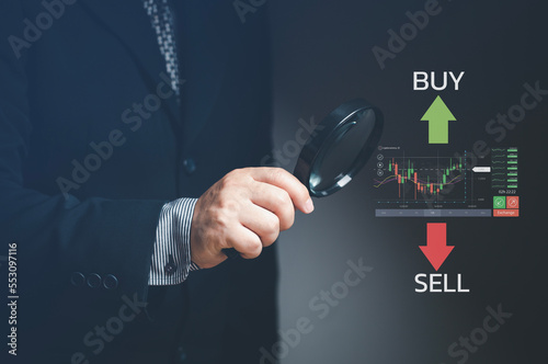 Businessman using data analysis tools to approve and make decisions in stock trading. Magnifier tool. Stock trading strategy. Stock market. Cryptocurrency.