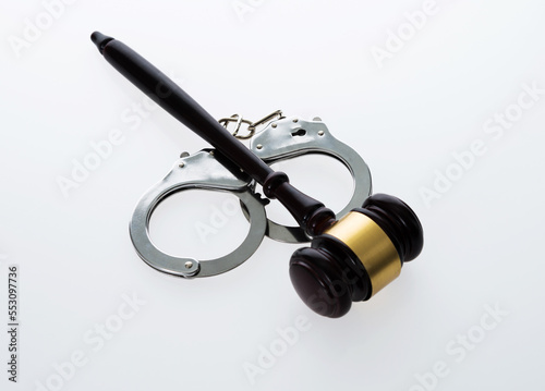 Wooden judge gavel and police handcuffs isolated on white background