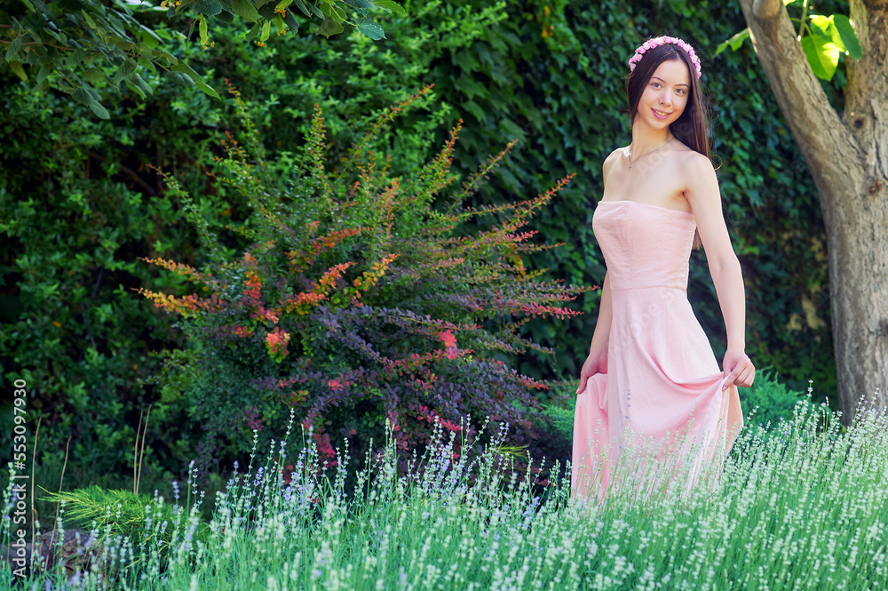 Young woman in a pink dress in nature