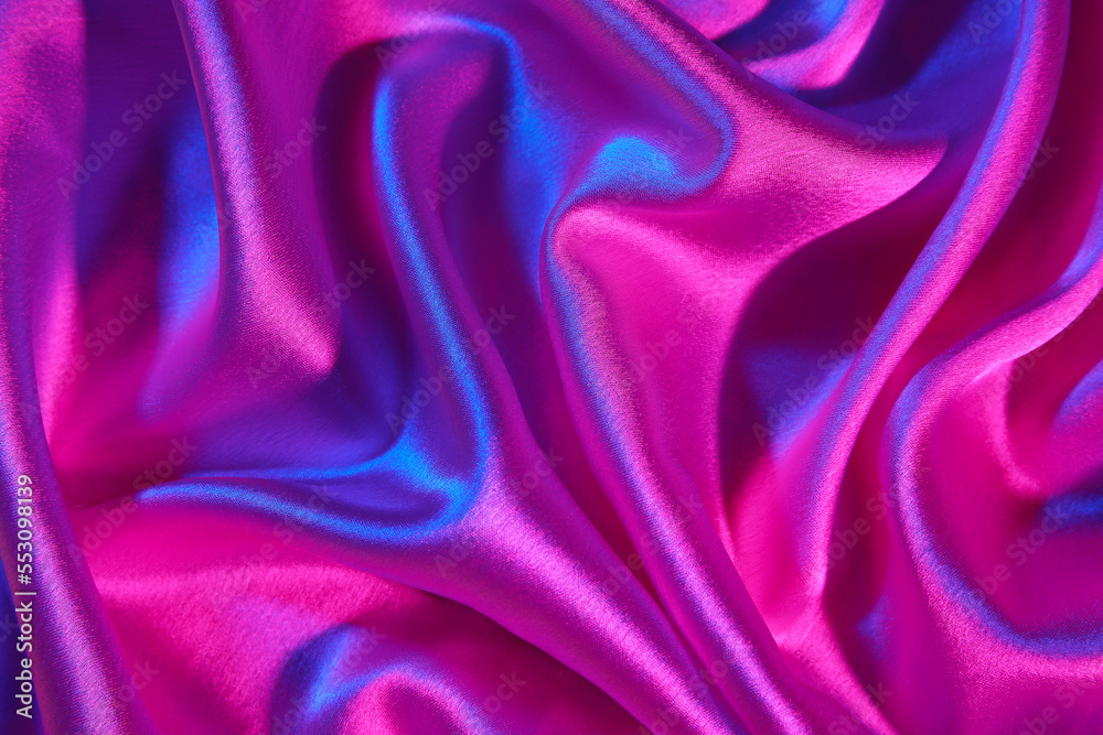 Obraz premium Crumpled silky fabric in neon light as background