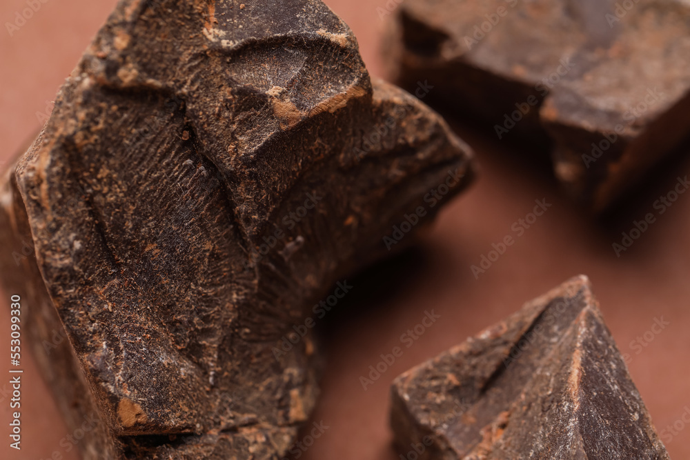 Pieces of delicious chocolate on brown background, closeup Pieces of delicious chocolate on brown background, closeup
