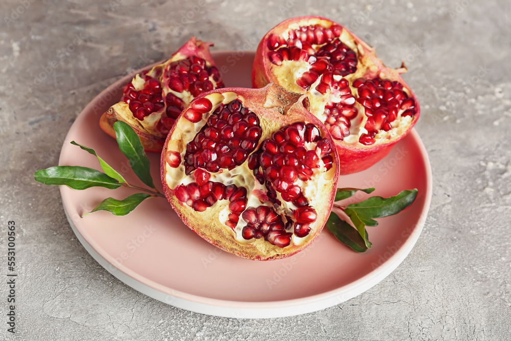 Plate of fresh pomegranates on grunge background Plate of fresh pomegranates on grunge background