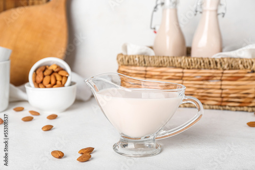 Gravy boat of almond milk on light background