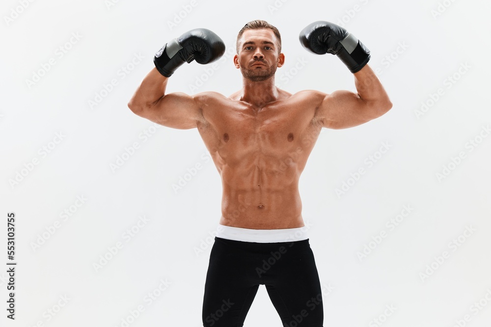 Man athletic bodybuilder poses in boxing gloves with nude torso abs in full-length background, boxing and martial arts. Advertising, sports, active lifestyle, competition, challenge concept. Man athletic bodybuilder poses in boxing gloves with nude torso abs in full-length background, boxing and martial arts. Advertising, sports, active lifestyle, competition, challenge concept.