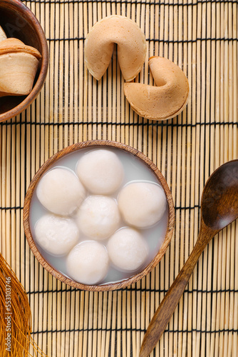 Bowl of tangyuan and fortune cookies on bamboo mat. Dongzhi Festival