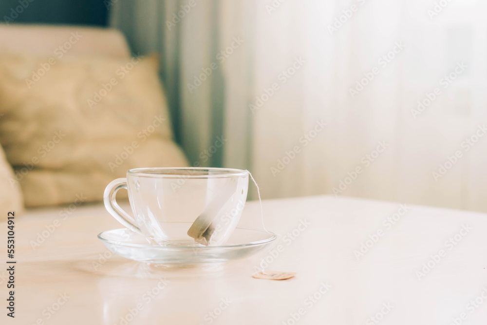 Empty glass cup with tea bag on the table, homemade tea party. Copy space selective focus Empty glass cup with tea bag on the table, homemade tea party. Copy space selective focus