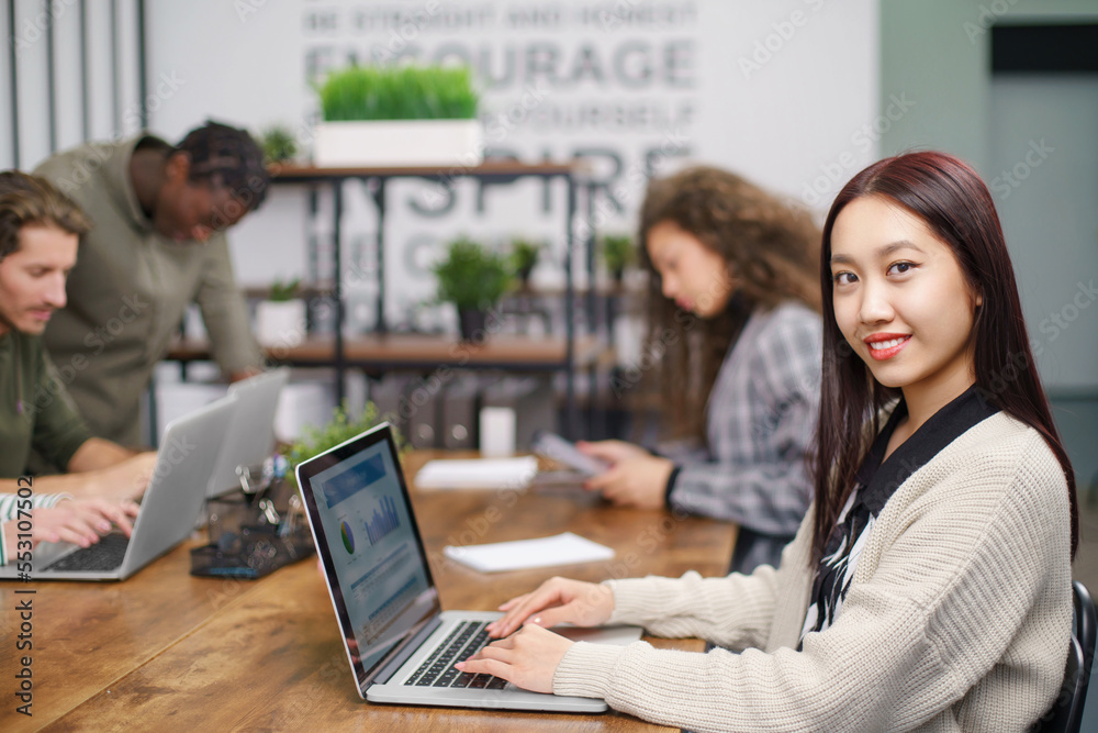 Obraz premium portrait of a young business woman at a table in a coworking center.