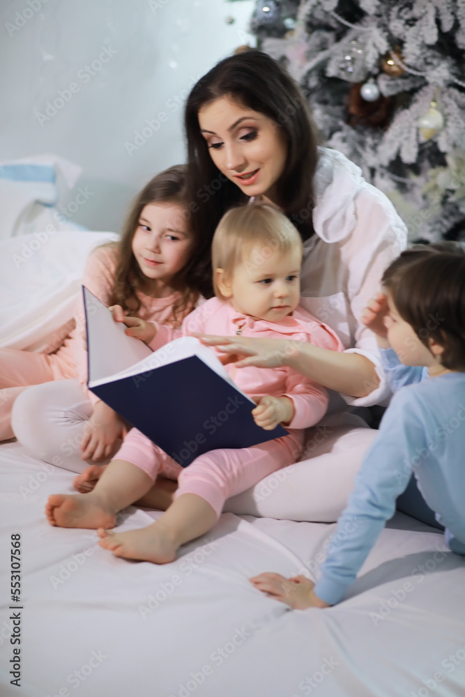 A family with children having fun on the bed under the covers during the Christmas holidays. A family with children having fun on the bed under the covers during the Christmas holidays.
