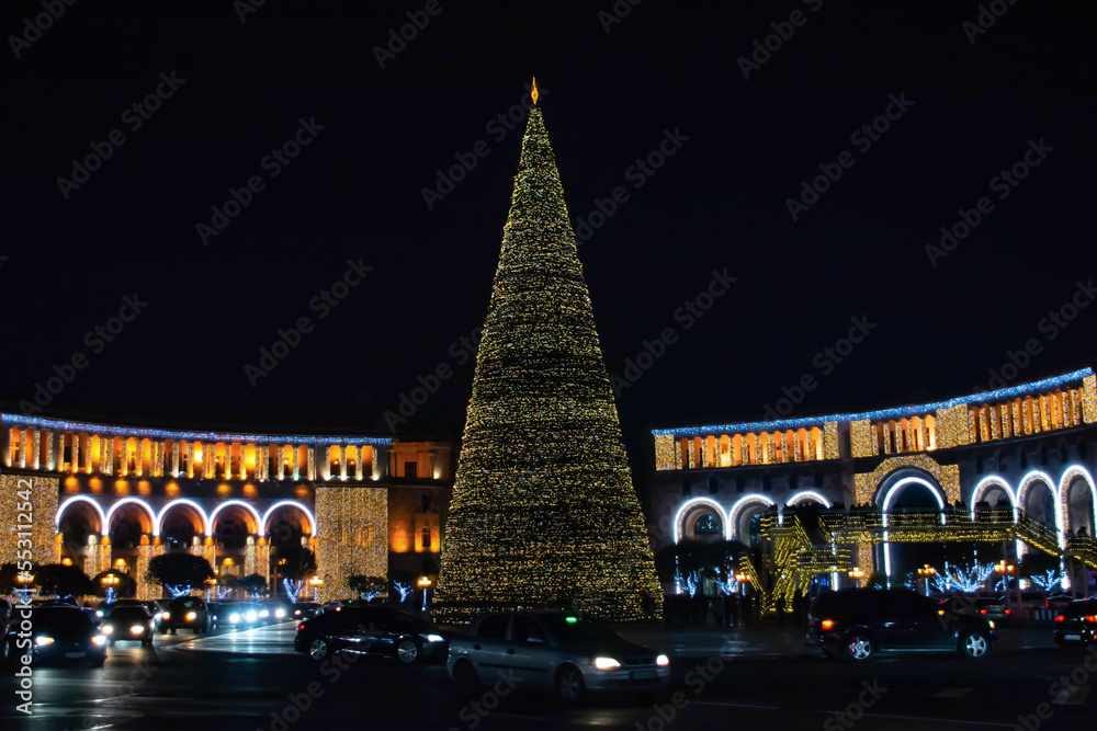 New Year's huge tree and city lights. New Year tree in Yerevan, Armenia. Glowing buildingс