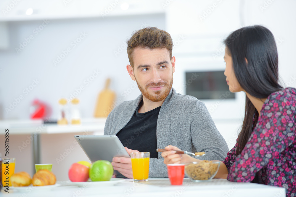 Using tablet computer whilst eating breakfast Using tablet computer whilst eating breakfast