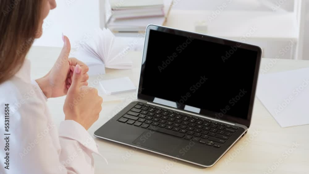 Online approval. Video call. Successful negotiation. Unrecognizable satisfied business woman supporting with thumbs up at mockup laptop with blank copy space black screen. Online approval. Video call. Successful negotiation. Unrecognizable satisfied business woman supporting with thumbs up at mockup laptop with blank copy space black screen.