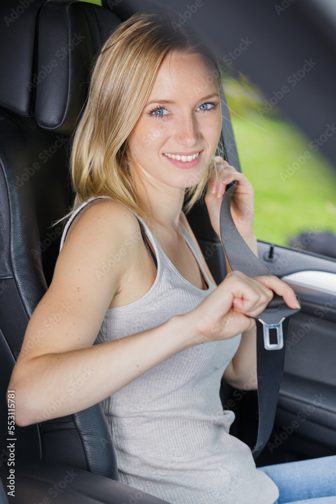 passenger woman fastening seat belt in the car passenger woman fastening seat belt in the car