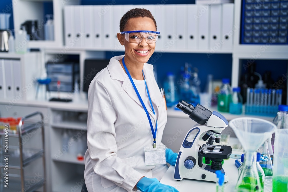 African american woman scientist using microscope at laboratory African american woman scientist using microscope at laboratory