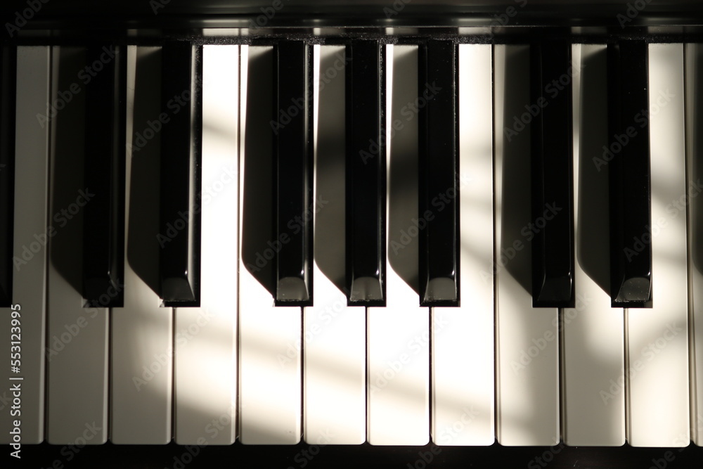 Fototapeta premium Sunlight on Piano, keyboard close up instrument playing music, practing and celebrate. Top view of keys