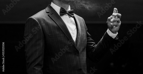 man in suit using perfume