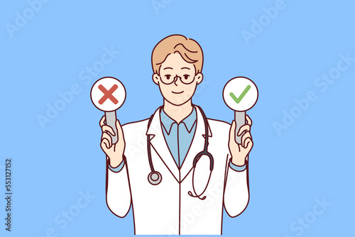 Man doctor with stethosop around neck demonstrates signs with check mark and cross. Young guy therapist in white coat shows signs of presence or absence of disease in patient. Flat vector design 