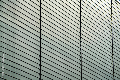 Detail or texture shot side of building facade and slatted wood pannels on exterior of black gray building in the downtown city
