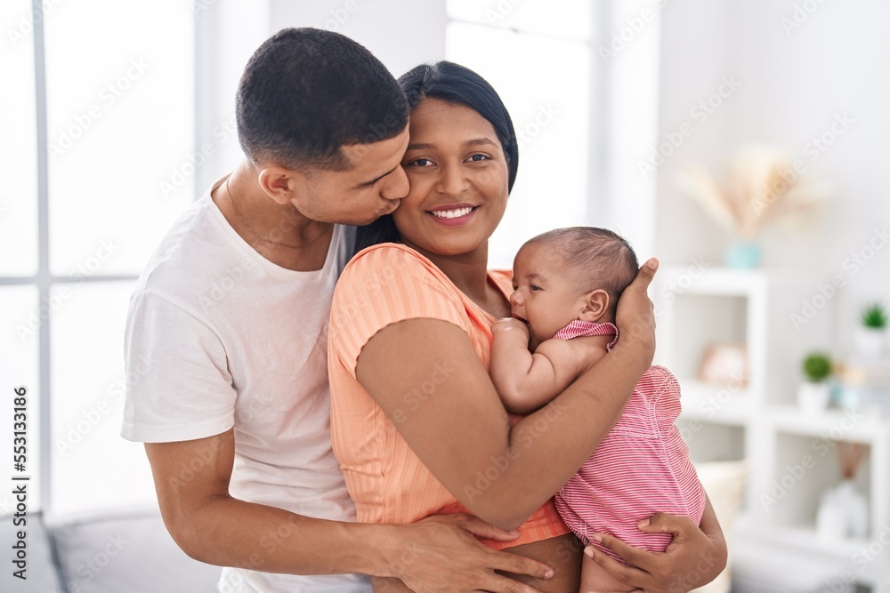 Fototapeta premium Hispanic family hugging each other kissing at home