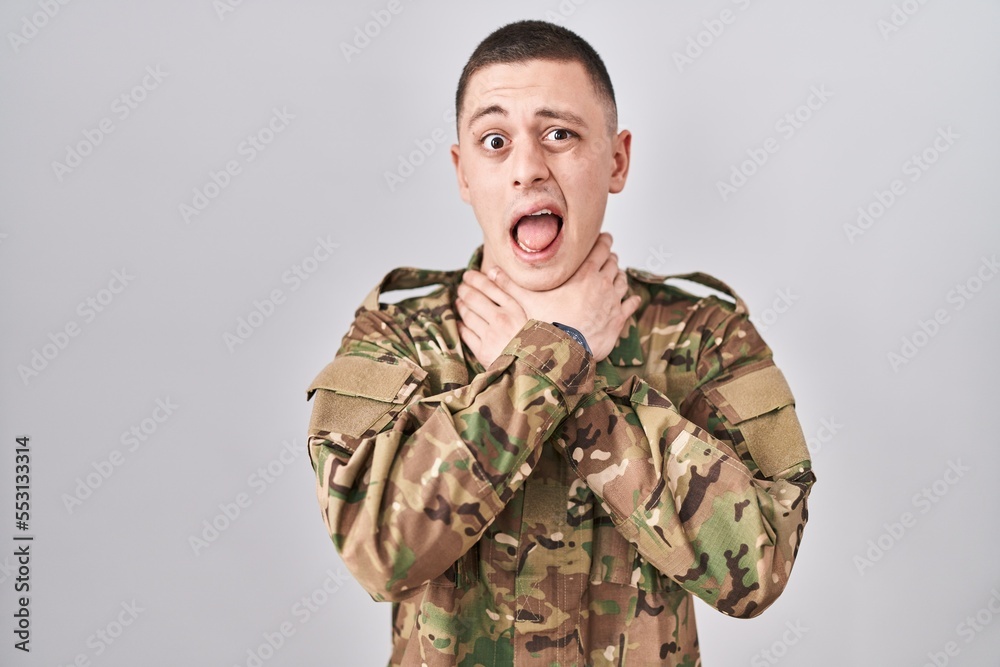 Young man wearing camouflage army uniform shouting and suffocate because painful strangle. health problem. asphyxiate and suicide concept.