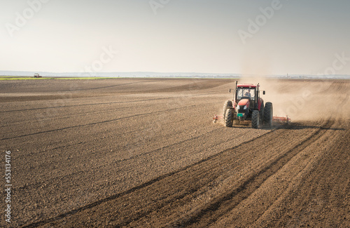 Tractor is preparing the land at dusk