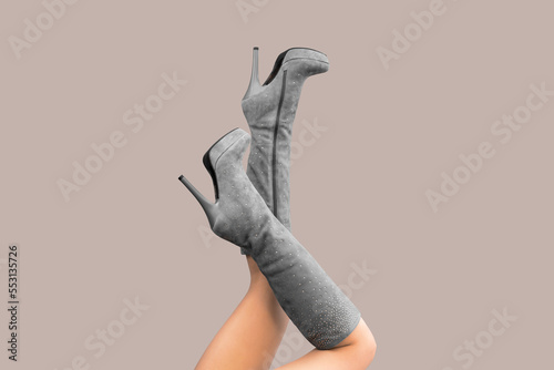 Sexy woman legs up in gray suede knee with rhinestones high stiletto high heels platform boots isolated on gray background Fototapet