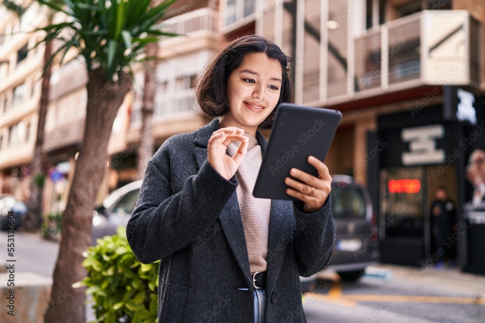 Young woman smiling confident using touchpad at street Young woman smiling confident using touchpad at street