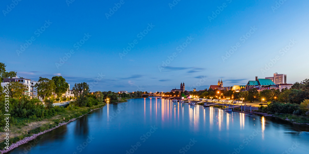 Germany, Saxony-Anhalt, Magdeburg, Long exposure of Elbe river flowing through city at dusk Germany, Saxony-Anhalt, Magdeburg, Long exposure of Elbe river flowing through city at dusk