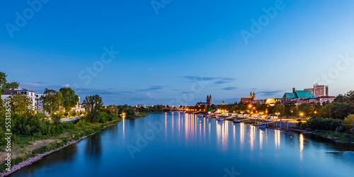 Germany, Saxony-Anhalt, Magdeburg, Long exposure of Elbe river flowing through city at dusk photo