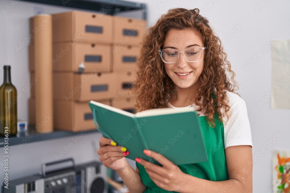 Young beautiful hispanic woman artist smiling confident reading book at art studio Young beautiful hispanic woman artist smiling confident reading book at art studio