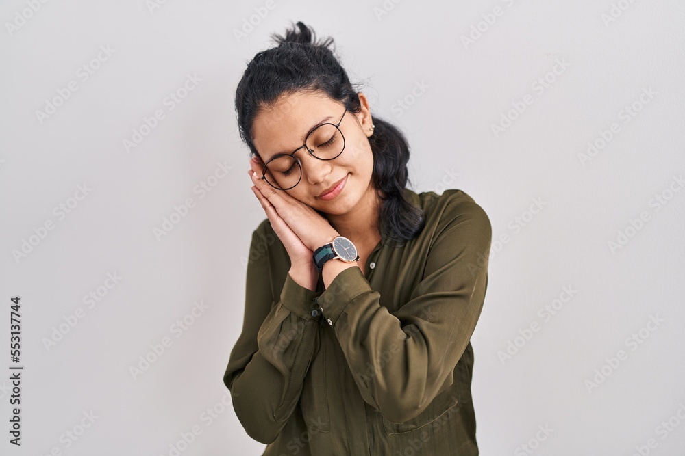 Hispanic woman with dark hair standing over isolated background sleeping tired dreaming and posing with hands together while smiling with closed eyes. Hispanic woman with dark hair standing over isolated background sleeping tired dreaming and posing with hands together while smiling with closed eyes.