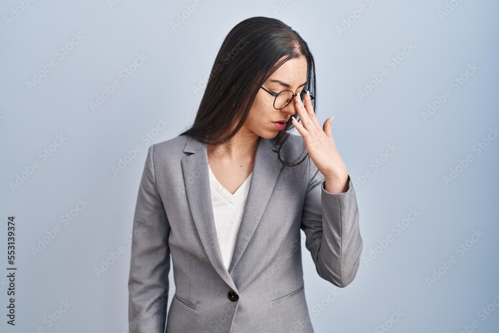 Hispanic business woman wearing glasses tired rubbing nose and eyes feeling fatigue and headache. stress and frustration concept. Hispanic business woman wearing glasses tired rubbing nose and eyes feeling fatigue and headache. stress and frustration concept.