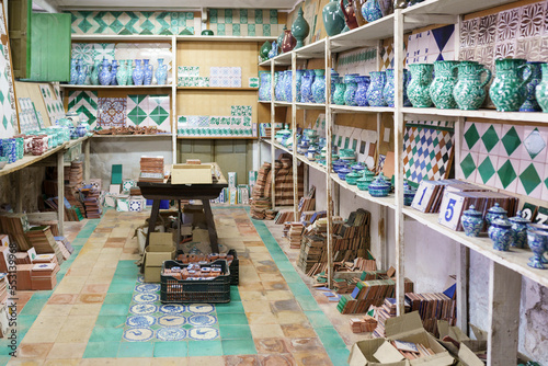 Various ceramic pieces arranged on rack in workshop photo